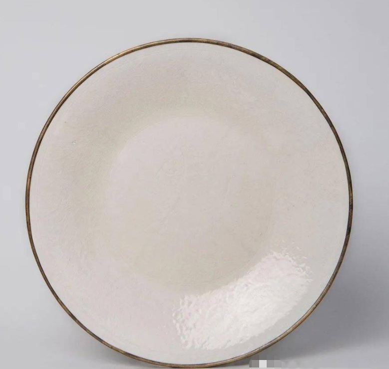 雍正時期仿定窯之作，與臺北故宮收藏的宋代定窯白釉雙魚盤十分相似